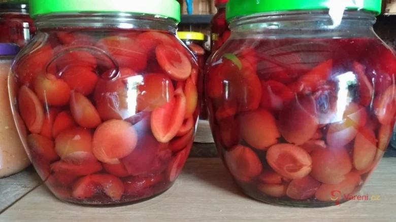 Dva sklenice s nakládanými švestkami v sirupu.