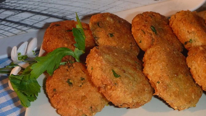 Zlatohnědé smažené falafele s čerstvou petrželkou na talíři.