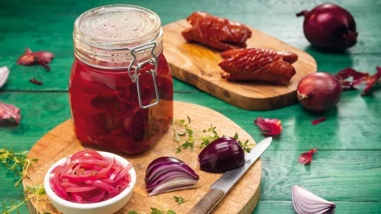Sklenice nakládané červené cibule s kousky pečeného kačičího masa.
