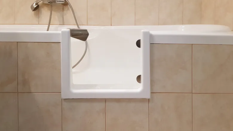 Bílá vana s nainstalovaným přenosem pro sprchování.