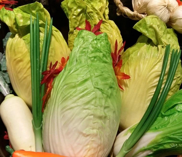 Čerstvé pekingské zelí s cibulkou v košíku.