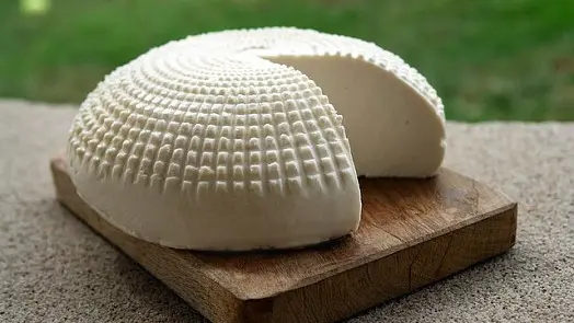 Whey cheese wheel with slice removed