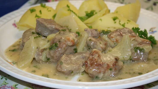 Maso v zakysané smetaně s bramborami na talíři