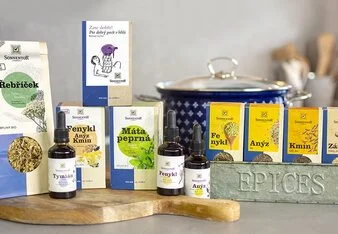 Sada balení feniklu s olejem a dalšími koření na dřevěném podnose.