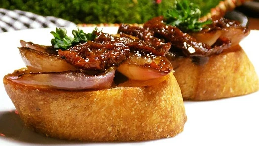 Pikantní bruschetta s pečenou šalotkou a bylinkami.