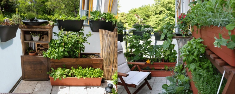 Zelená zahrada na balkóně s dřevěnými kvetináči a bylinkami.