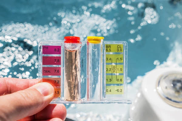 Testovací proužek pro kontrolu chemie vody v zahradní vířivce.