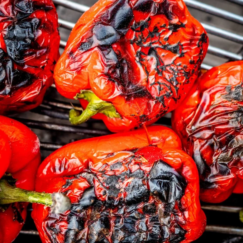 Grilované červené papriky s ohořelou kůrou pro domácí ajvar.