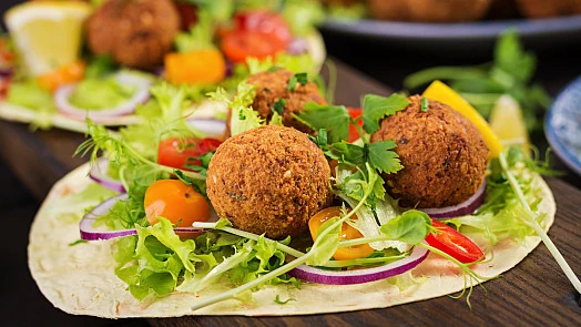 Falafely s čerstvou zeleninou v plackách na talíři.