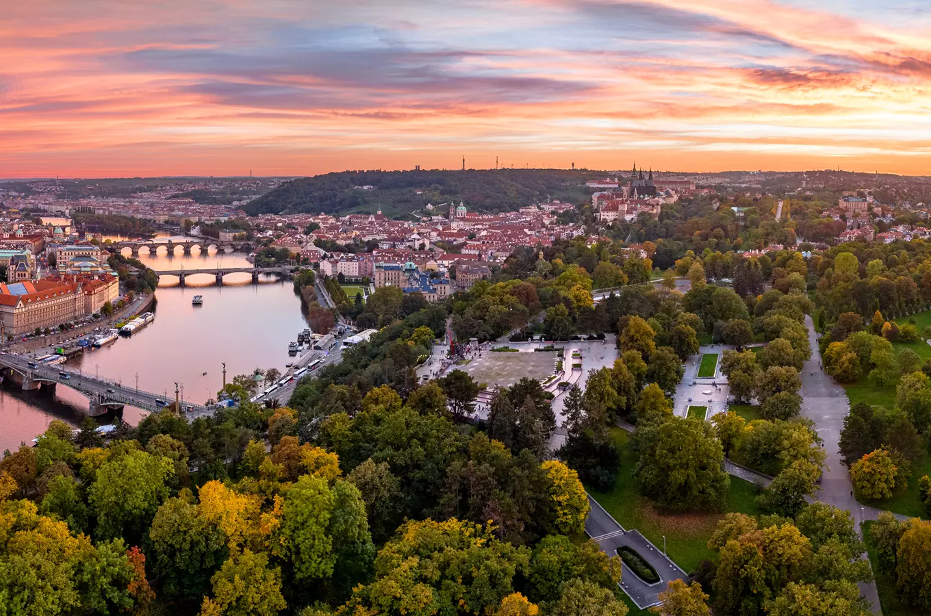 Pohled na Pražský hrad a Vltavu s botanickou zahradou v popředí.