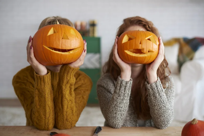 Dvě dívky s vyřezanými dýněmi na Halloween