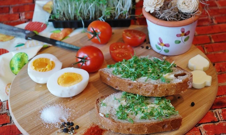 Chleba s řeřichou, vejcem a rajčaty na dřevěném prkénku