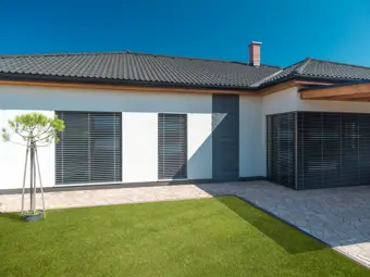 Moderní dům s předokenními žaluziemi pro ochranu proti slunci.