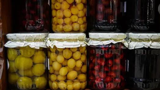 Sklenice s ovocem po sterilizaci v troubě pro domácí konzervace.