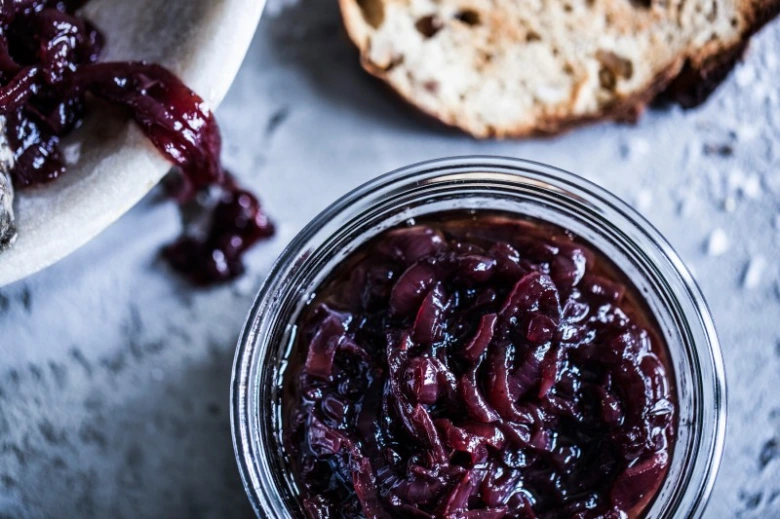 Sklenice s červenou cibulovou chutney na snídani.