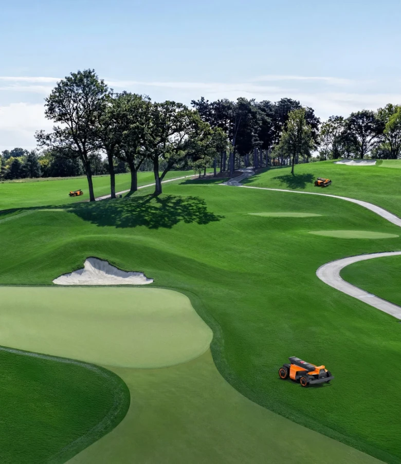 Robotické sekačky na trávu pracují na golfovém hřišti.