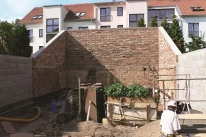 Stavba zahrady s cihlovými zdmi a dřevěnými prvky.
