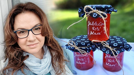 Žena s třemi sklenicemi domácího jablečných povidel na stole.
