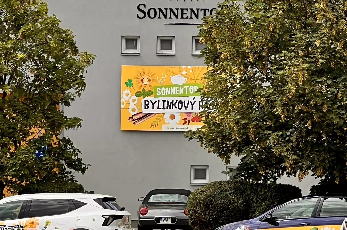 Fotografie budovy firmy Sonnentor s reklamou na bylinné produkty.