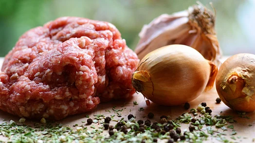 Suroviny pro masovou směs: hovězí mleté, cibule, česnek a koření.